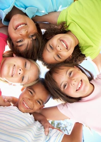5 children huddled together smiling 